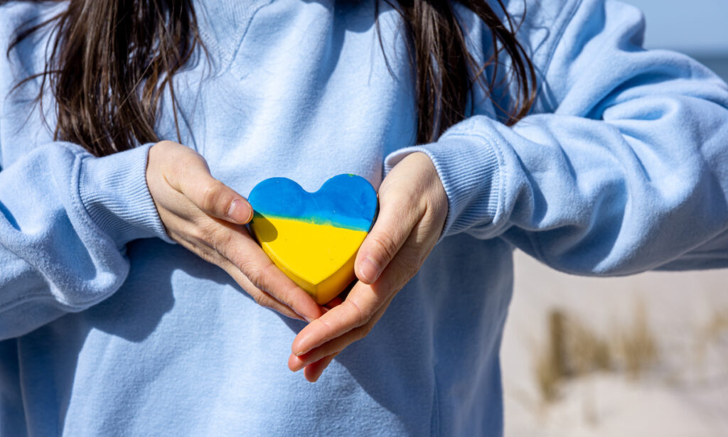 Herz in der Farbe der Flagge der Ukraine in weiblichen Händen, das Konzept des Friedens in der Ukraine, kein Krieg. Wunderflats Wohnraumaktion