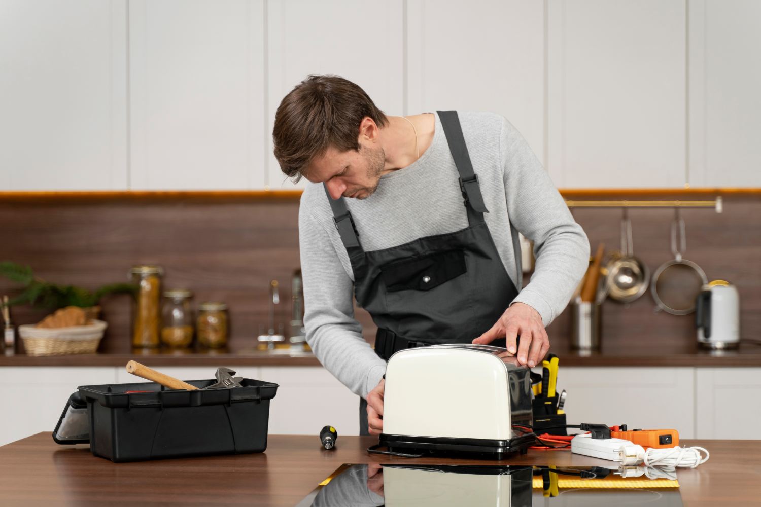 Die Wartung von Haushaltsgeräten: ein Mann repariert einen Toaster