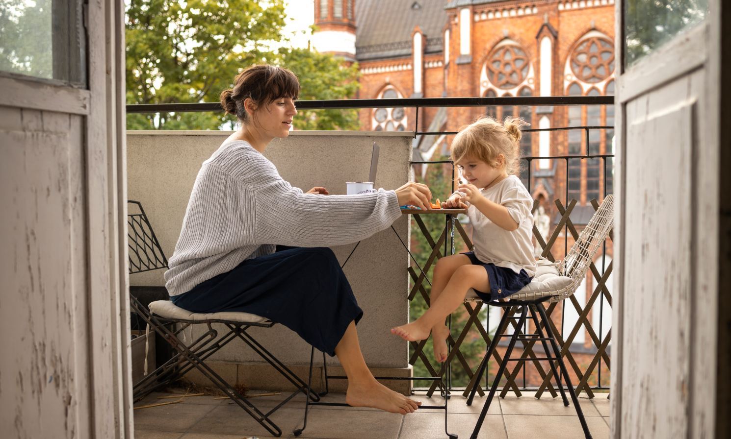Ruhezeiten in einer mietwohnung. Eine Mutter und ihre kleine Tochter verbringen eine ruhige Zeit auf einem Balkon.