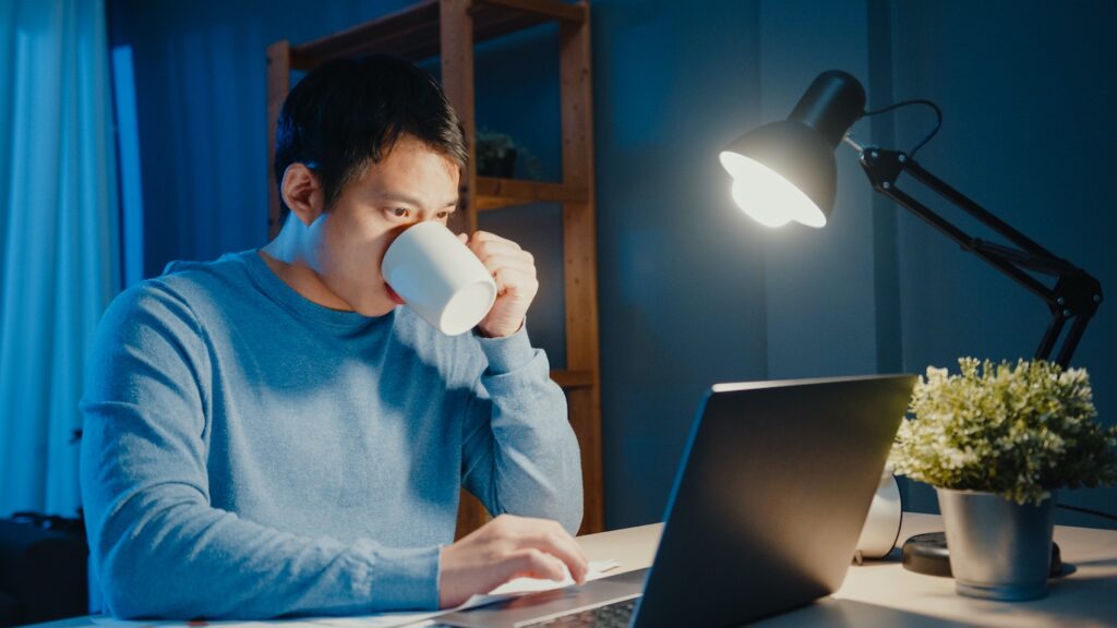 Kann man Mieter:innen wegen Eigenbedarf kündigen? Ein Mann schaut konzentriert auf einen Laptop und trinkt Kaffee.