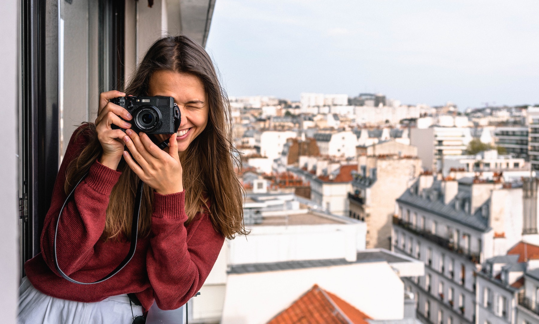 Woman taking a photo standing on a balcony. A guide to apartment photos