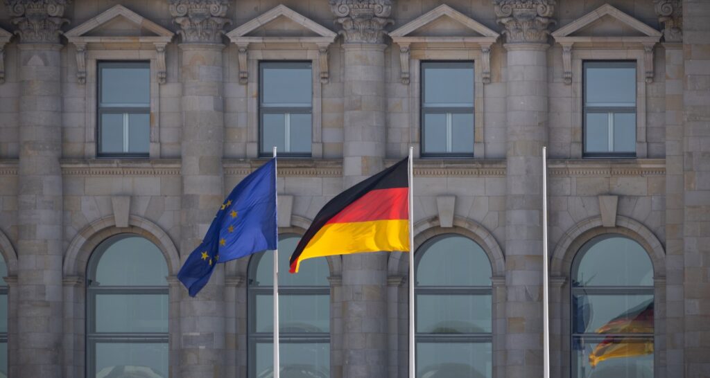 How to get your residence permit in Germany/. An EU flag and a German flat in front of the Reichstag.